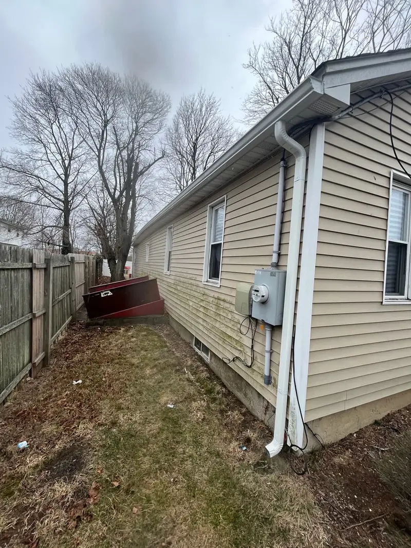 Side yard with a basement bulkhead and old fence, Amityville, NY